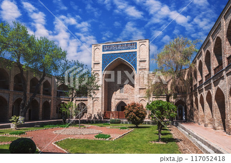 courtyard of ancient Uzbek Kukeldash Madrasah in Tashkent in Uzbekistan. Medieval historic Islamic madrassah under beautiful blue sky in summer 117052418