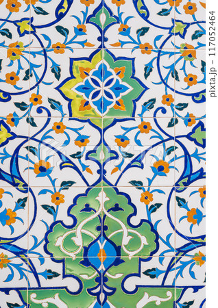 ceramic tile with traditional Uzbek floral ornament with a pattern of flowers. Wall of white mosque Minor in Tashkent in Uzbekistan 117052464