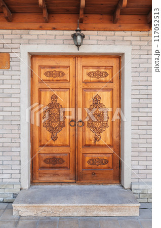 modern wooden door with a traditional oriental Uzbek carved pattern decorated ornaments in Uzbekistan modern wooden door with a traditional oriental Uzbek carved pattern decorated ornaments in Uzbekistan 117052513