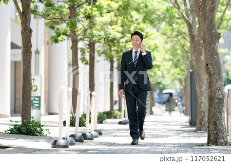 ビジネスマン　スマホ　通話　歩く 117052621