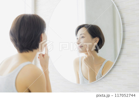 洗面所で鏡を見るミドルの女性 洗面所で鏡を見るミドルの女性 117052744