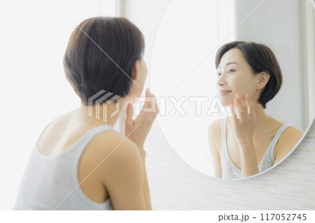 洗面所で鏡を見るミドルの女性　 117052745