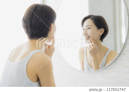 洗面所で鏡を見るミドルの女性　 117052747