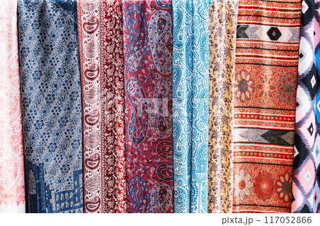 Traditional silk Indian scarves with a bright colorful pattern at an Asian bazaar in India close up Traditional silk Indian scarves with a bright colorful pattern at an Asian bazaar in India close up 117052866