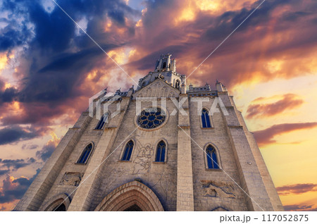 tower with cross of gothic ancient Catholic Cathedral on background of dramatic cloudy sky. Church of Sacred Heart of Jesus in Tashkent in Uzbekistan 117052875