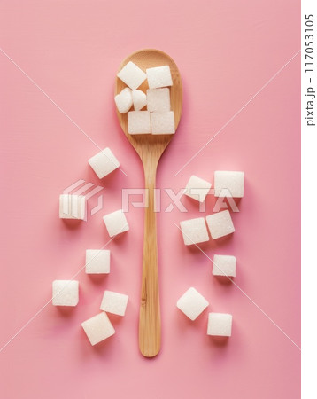 A spoonful of sugar cubes is on a pink background 117053105