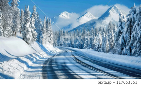 A snowy mountain range is in the background of a road A snowy mountain range is in the background of a road 117053353