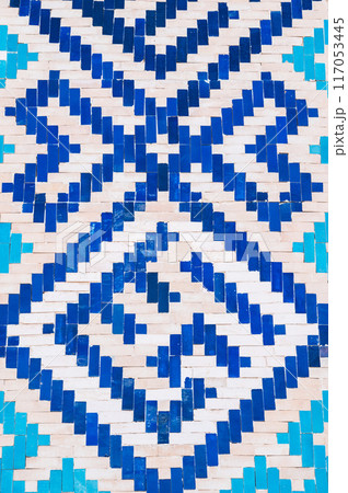 ancient ceramic tile with a traditional Asian pattern Uzbek ornament decorates wall of islamic Barakhan Madrasah in Tashkent, Uzbekistan 117053445