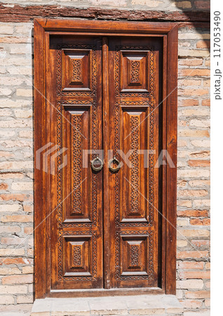 carved wooden door to islamic Kukeldash Madrasah with uzbek pattern decorated with oriental arabic ornaments in Uzbekistan in Tashkent 117053490
