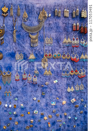traditional oriental Uzbek earrings and women's jewelry on the counter at bazaar in Uzbekistan traditional oriental Uzbek earrings and women's jewelry on the counter at bazaar in Uzbekistan 117053491