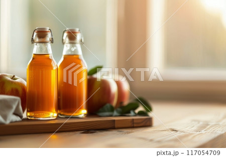 Freshly Pressed Apple Juice Jars on Rustic Wooden Table With Autumn Apples at Sunset 117054709