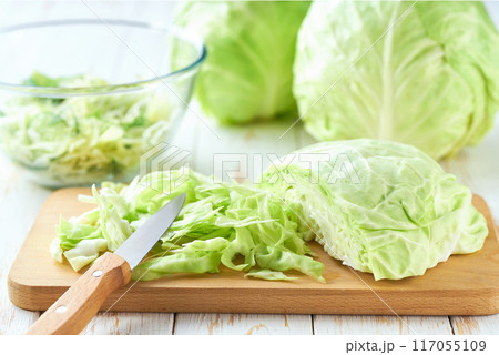 chop fresh cabbage to make a vegetarian salad. 117055109