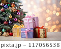 Beautifully wrapped gifts under a decorated Christmas tree with colorful ornaments 117056538