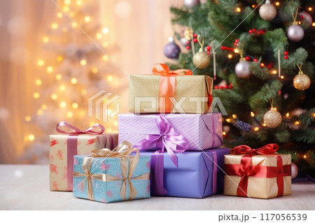 Holiday gifts arranged near a decorated tree, holiday background with copy space 117056539