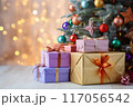 Festively wrapped presents lying under a decorated Christmas tree with twinkling lights 117056542