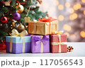 Attractive gifts wrapped in colorful paper beneath a cheerful Christmas tree 117056543