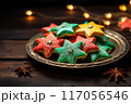 A plate has green, red, and yellow star cookies with sprinkles, Christmas sweets 117056546