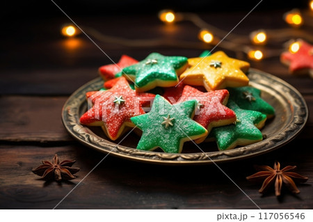 A plate has green, red, and yellow star cookies with sprinkles, Christmas sweets 117056546