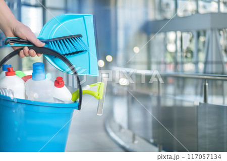 Cleaning Lady with Cleaning Products on a Blurred Background. Cleaning Lady with Cleaning Products on a Blurred Background. 117057134