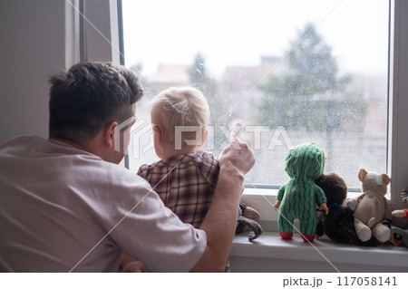 Father with toddler girl daughter looking into window Father with toddler girl daughter looking into window 117058141