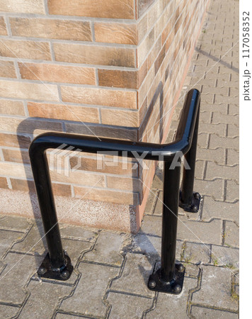 Black Metal Parking Barrier Protecting Brick Wall 117058352