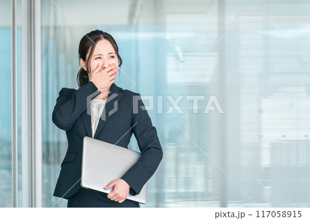 オフィスビルの前でショック・驚きで顔を覆う若いアジア人ビジネスウーマン(悲しい・リストラ・トラブル) オフィスビルの前でショック・驚きで顔を覆う若いアジア人ビジネスウーマン(悲しい・リストラ・トラブル) 117058915