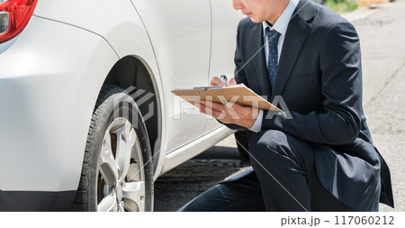 チェック表を使って車の査定・見積もりをするセールスマン・査定士の手元 117060212