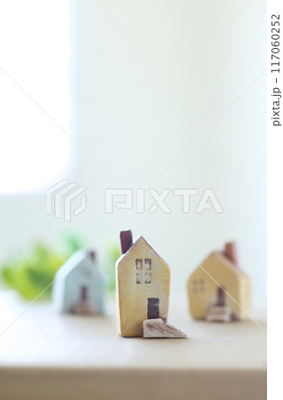 小さな家の模型を窓際に置いた光あふれるやわらかなマイホームのイメージ 小さな家の模型を窓際に置いた光あふれるやわらかなマイホームのイメージ 117060252
