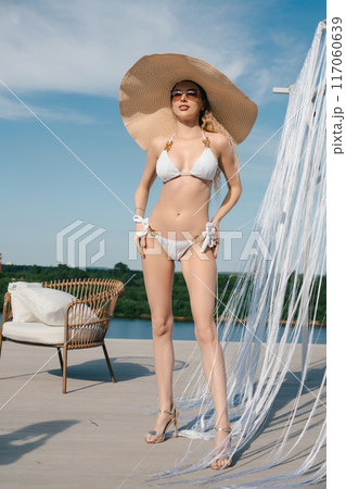 Woman In White Bikini On Rooftop Deck 117060639