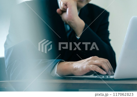 パソコンを見て悩むビジネスマン 117062823