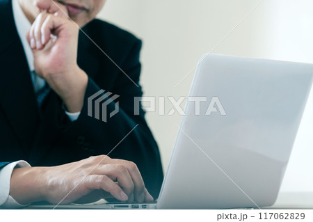 パソコンを見て悩むビジネスマン 117062829