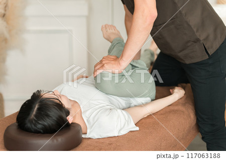 骨盤矯正・整体院・整骨院・マッサージに通う女性と整体師・セラピスト 117063188