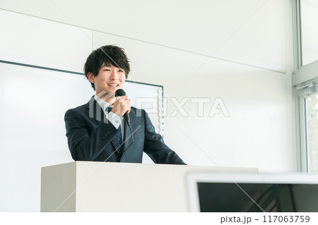 塾講師・セミナー・勉強会・研修・会議・講習会・ワークショップ・イベントで壇上で講義をする男性 117063759