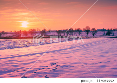 Evening in a winter village. Plowed field covered with snow 117065552
