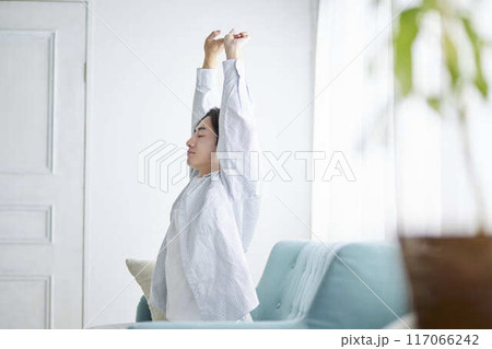 リビングで背伸びをする日本人の男性 リビングで背伸びをする日本人の男性 117066242