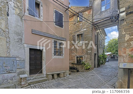 a large brick courtyard leading to two apartment buildings in an old town a large brick courtyard leading to two apartment buildings in an old town 117066356