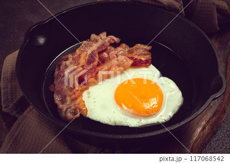 fried egg with bacon, in a cast-iron pan, breakfast, top view, close-up, homemade, no people, 117068542