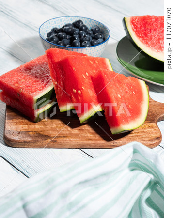 Seedless watermelon and blueberries on wooden background, summer fruit 117071070