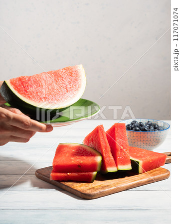 Female hands holding green dish with watermelon in summer 117071074