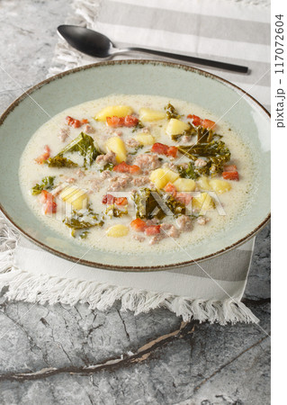 Zuppa Toscana hearty Tuscan Soup loaded with Italian sausage, kale, fried bacon and potatoes closeup on the plate. Vertical 117072604