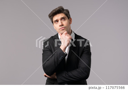 Thinking man looking up and around on grey background. Worried contemplative face expressions. Handsome male model in formal suit Thinking man looking up and around on grey background. Worried contemplative face expressions. Handsome male model in formal suit 117075566