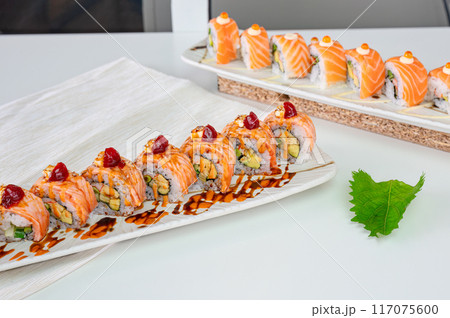 Ceramic tray with variety of salmon sushi roll with vegetables, appetizing japanese meal 117075600