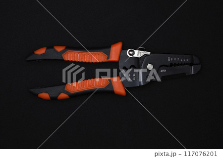 Insulation puller or stripper is an electrical installation tool on a black background. 117076201