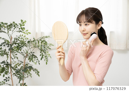 鏡を見ながら美顔器を使う女性 117076329
