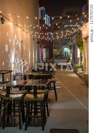 Outdoor bar tables and chairs at night, Bugis village, Singapore 117076720