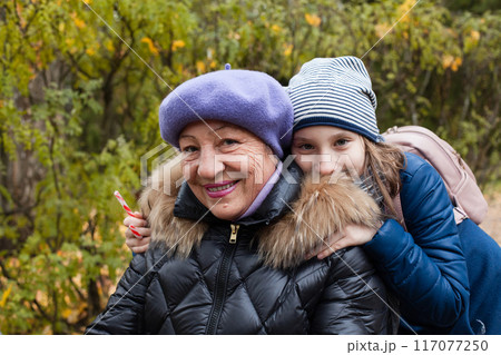 Grandmother with her granddaughter in autumn park outdoor Grandmother with her granddaughter in autumn park outdoor 117077250
