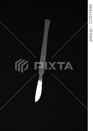 A scalpel on a black background. A medical instrument. A scalpel on a black background. A medical instrument. 117077699