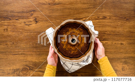 Flat lay. The gingerbread bundt cake gently eases out of its mold onto a wire rack, poised for a drizzle of sweet caramel frosting. Flat lay. The gingerbread bundt cake gently eases out of its mold onto a wire rack, poised for a drizzle of sweet caramel frosting. 117077716