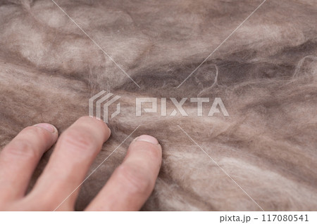 Construction worker thermally insulating house mineral wool attic with glass wool 117080541