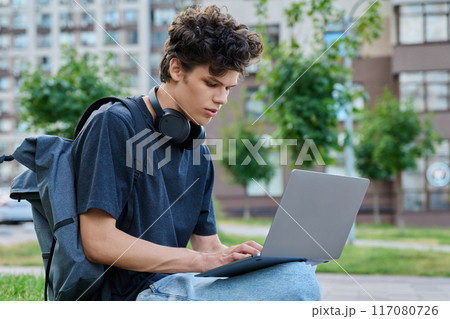 Young handsome male using laptop computer on city street Young handsome male using laptop computer on city street 117080726